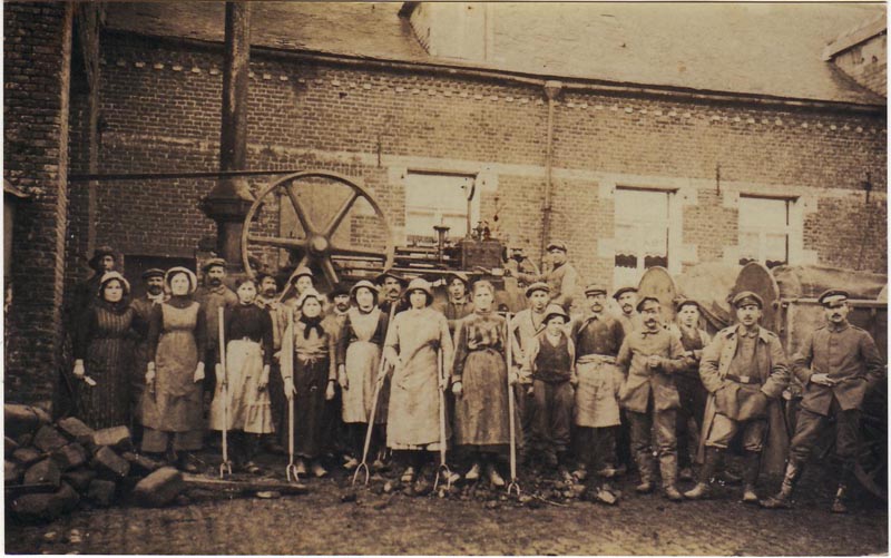 Ouvriers et soldats devant la batteuse dans la cour du Gard
