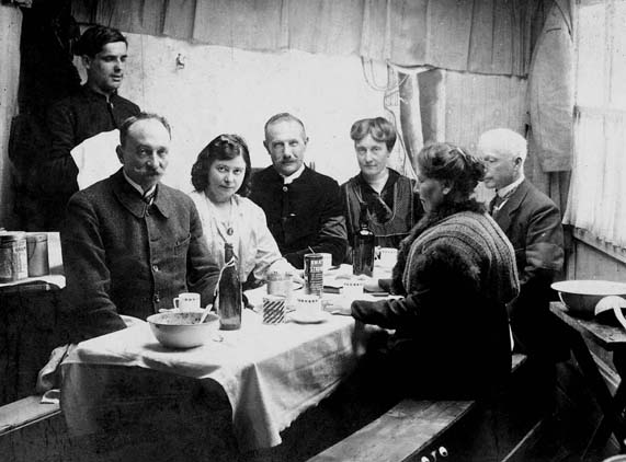 Assis à gauche, Pierre Brasseur.La troisième en partant de la droite est sa cousine Marguerite. Au dos de la carte, la mention suivante : A la baraque de Pierre, camp des hommes...